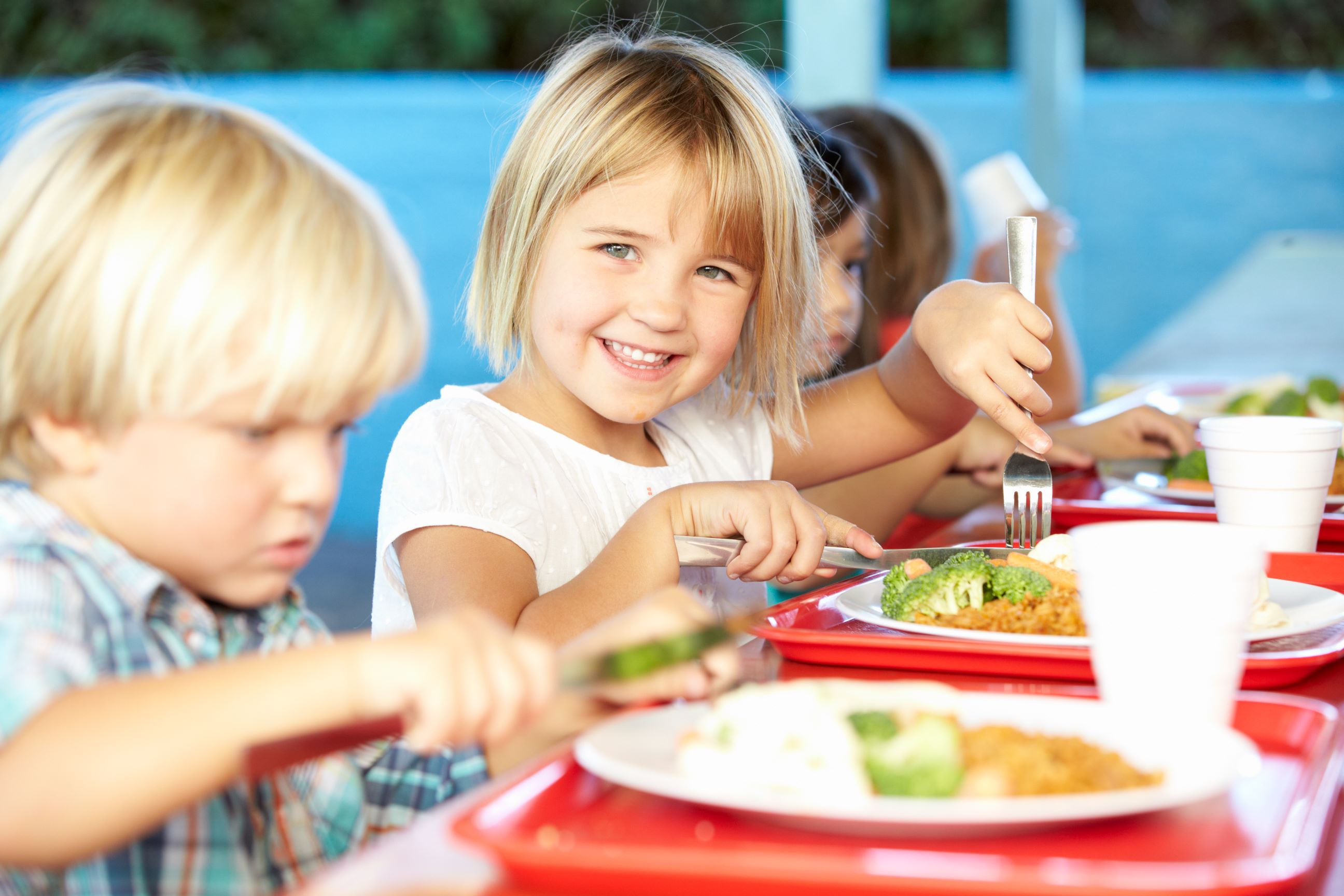 Elementare Schüler Genießen Sie gesunde Mittagessen In der Cafeteria serviert.